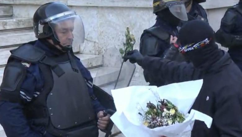 Protestuesi i maskuar "mbulon" policët me lule të thara, "u dhuron" puthje